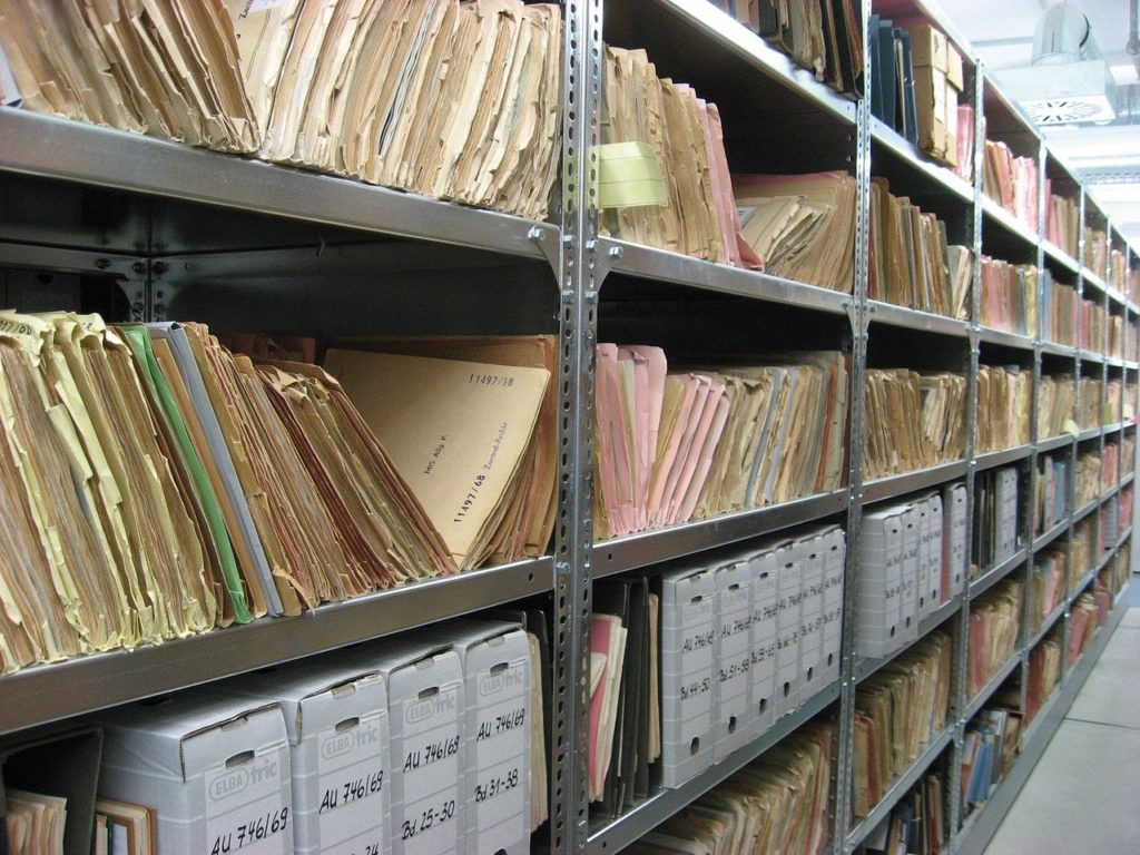 Long rows of tall shelves full of file folders and document storage boxes.
